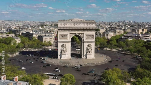 PARIS, FRANCE - OCTOBER 3, 2024: Breathtaking view of Arc de Triomphe surrounded by vibrant greenery and bustling traffic in Paris