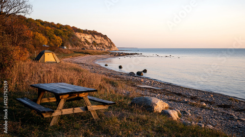 Serene campsite by cliff edge at sunset with picnic table