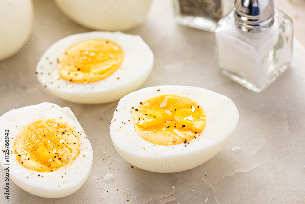 Soft boiled eggs cut in half with salt and pepper Soft boiled eggs cut in half with salt and pepper