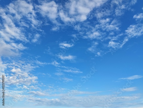 clear blue sky with a few clouds. The sky is very bright and the clouds are scattered throughout