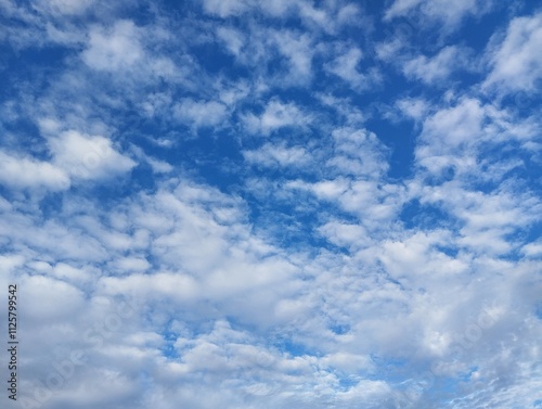 clear blue sky with a few clouds. The sky is very bright and the clouds are scattered throughout