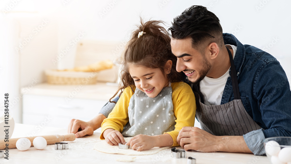 Cute little arab girl cutting out different cookie shapes from dough while baking with dad in kitchen, happy middle eastern father and daughter enjoying cooking pastry at home together, copy space Cute little arab girl cutting out different cookie shapes from dough while baking with dad in kitchen, happy middle eastern father and daughter enjoying cooking pastry at home together, copy space