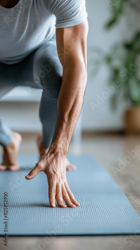 Close up man stretching his legs on yoga mat with focused expression