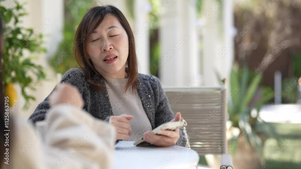 A Singaporean woman in her 40s and her 9-year-old daughter talk at a lovely cafe decorated for Christmas in downtown Shanghai, China.