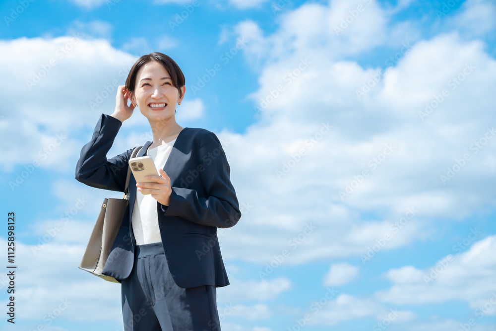 ビジネス女性・青空・スマートフォン