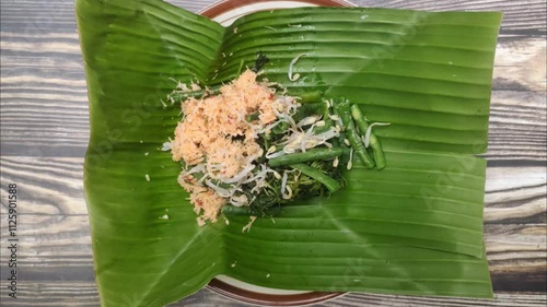 Gudangan is a traditional dish from Java, Indonesia made from a variety of green vegetables such as spinach, papaya leaves and others that are boiled, then mixed with grated coconut sauce. photo