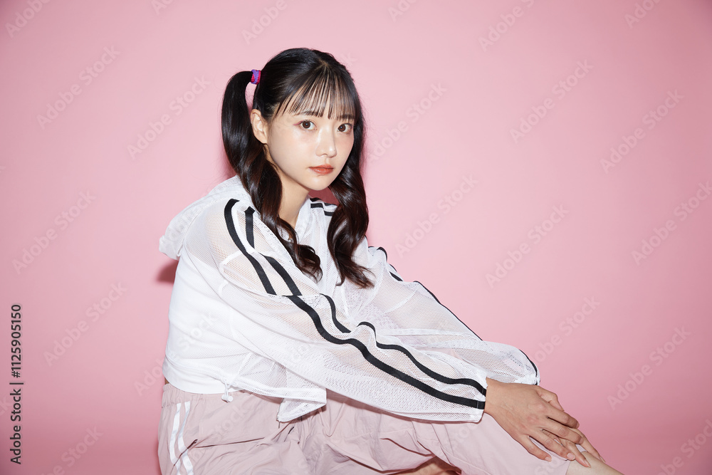 ピンク背景で撮影をしたスポーティな服装をした若い女性のキュートなポートレート ピンク背景で撮影をしたスポーティな服装をした若い女性のキュートなポートレート