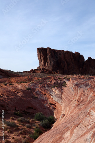 A bright red rock standing alone in Red Rocks Canyon. Futuristic landscape with red and white stripes going to the rock.