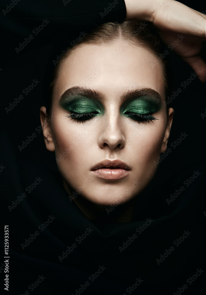 model wearing avant garde green smoky makeup with black background model wearing avant garde green smoky makeup with black background