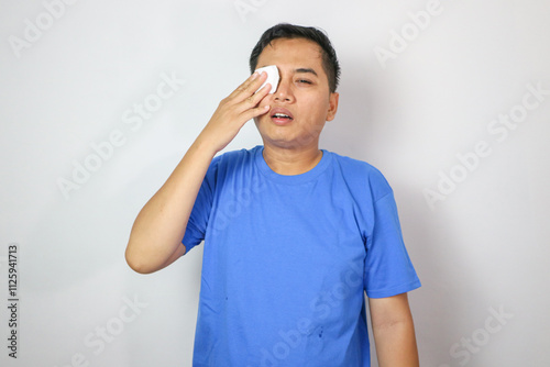 Eye injury emergency first aid medical bandage of an Asian man. Portrait image, copy space.