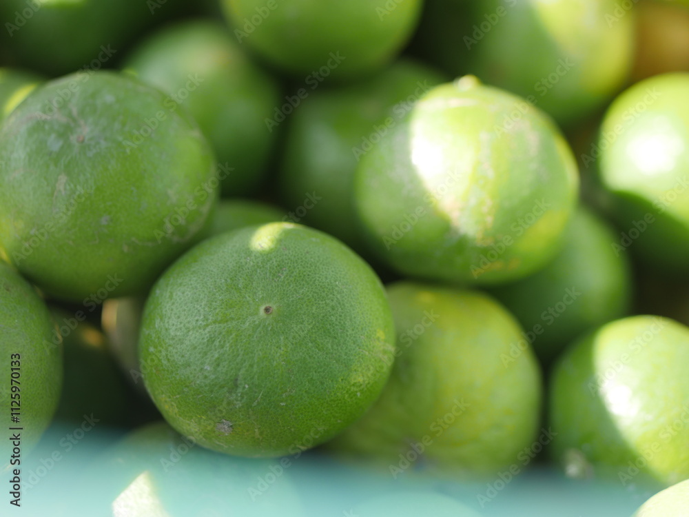 Many fresh limes with green leaves as background, top view Many fresh limes with green leaves as background, top view