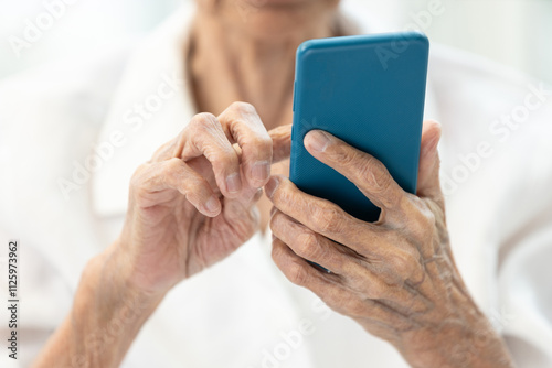Closeup of hands,Asian senior woman using smartphone,old elderly holding mobile phone,concept of technology, financial deception,cybercrime,victim of scams,internet fraud,online scams, cyber threats