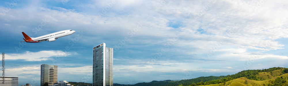 Commercial airplane flying in the sky above the city skyline with a cloudscape background Commercial airplane flying in the sky above the city skyline with a cloudscape background