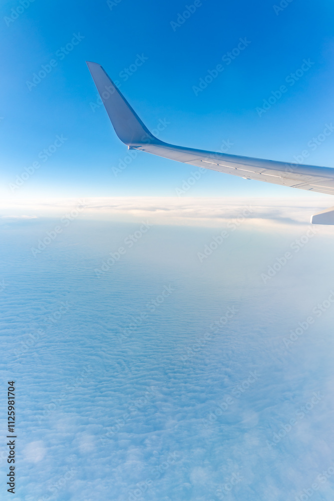 View from the airplane window at a beautiful cloudy sky and the airplane wing View from the airplane window at a beautiful cloudy sky and the airplane wing
