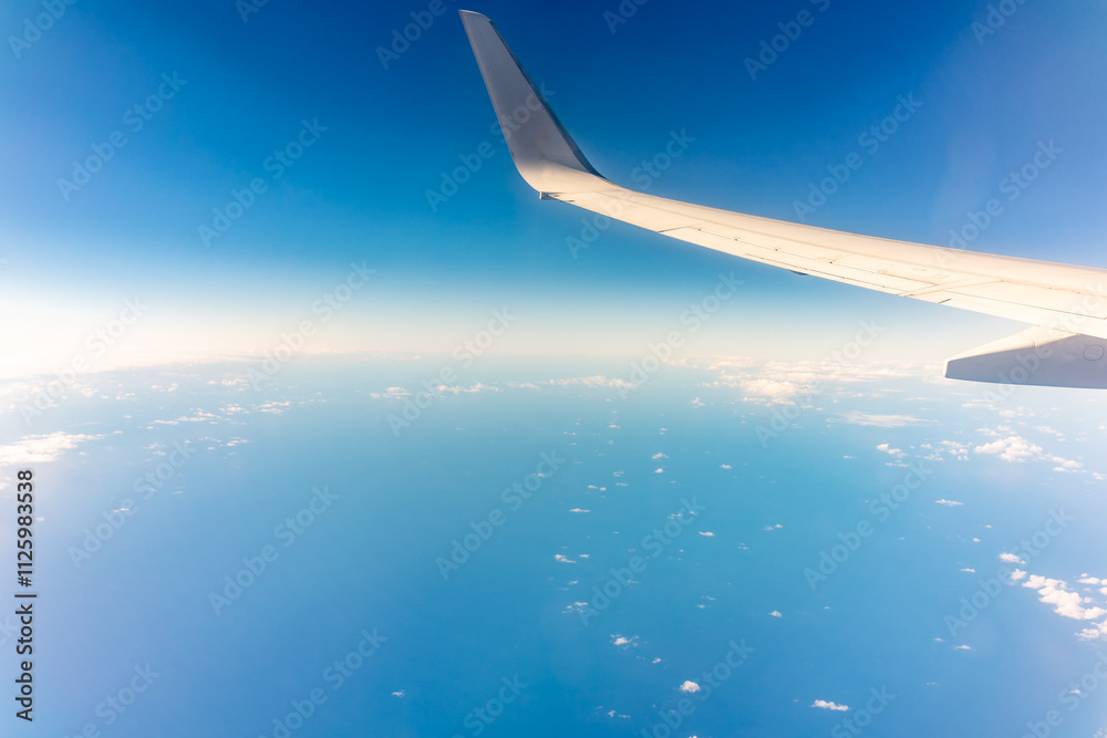 View from the airplane window at a beautiful blue clear sky and the airplane wing View from the airplane window at a beautiful blue clear sky and the airplane wing