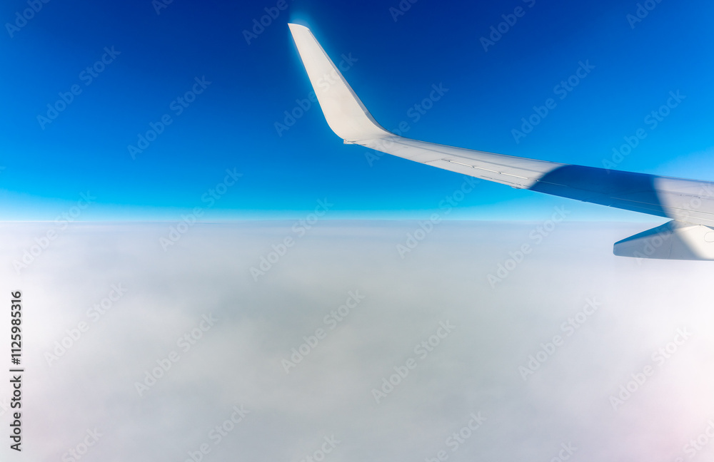 View from the airplane window at a beautiful cloudy sky and the airplane wing View from the airplane window at a beautiful cloudy sky and the airplane wing