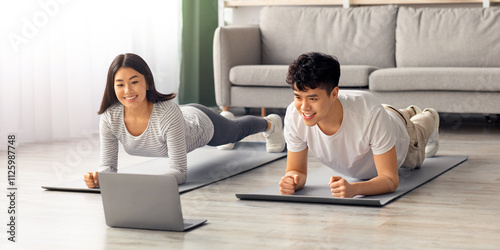 Slika na platnu Athletic asian couple having online fitness class at home, using laptop