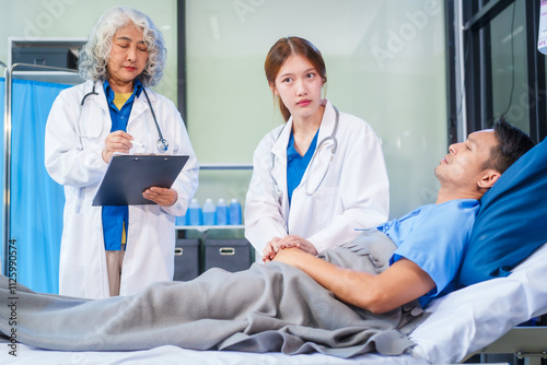 Two female doctors examine a patient lying on a hospital bed,discuss the medical chart,administer medicine,and provide encouragement, ensuring compassionate care and fostering the patient's recovery