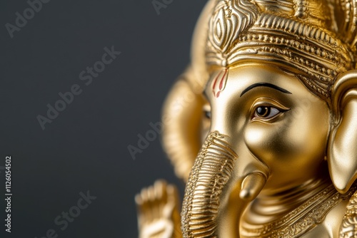 Close-up of golden ganesha statue with intricate details and calm expression