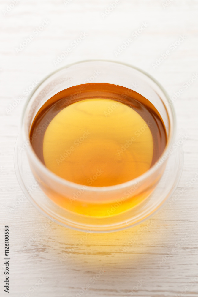 Cup of hot tea blended from rooibos, spearmint, apple, baobab on white wooden table.