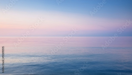 A serene image of a calm ocean at dawn, with soft pastel colors reflecting off the smooth water surface.