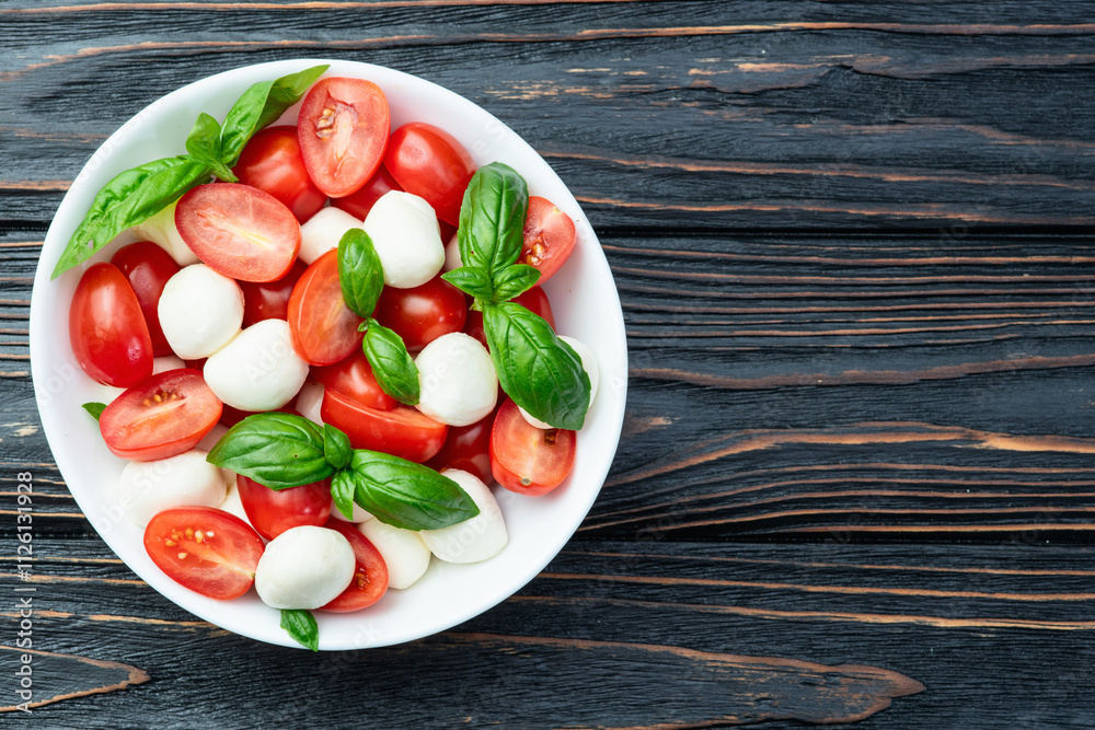 Basil leaves , cherry tomatoes and mozzarella cheese . In bowl food photography Basil leaves , cherry tomatoes and mozzarella cheese . In bowl food photography