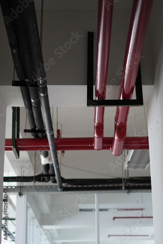 Pipes of different colors on the ceiling of a multi-storey building photo