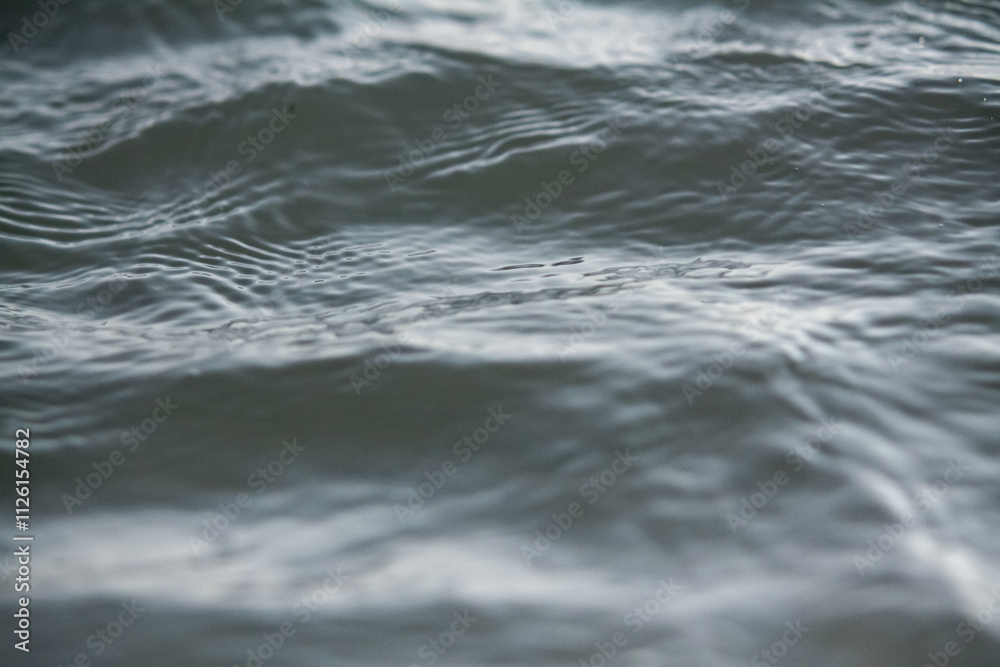 The water is calm and still, with ripples forming on the surface. Concept of tranquility and peacefulness. The water is calm and still, with ripples forming on the surface. Concept of tranquility and peacefulness.