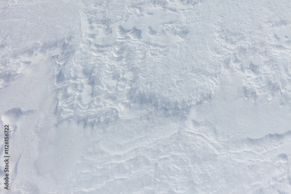 A snow covered ground with a few footprints A snow covered ground with a few footprints