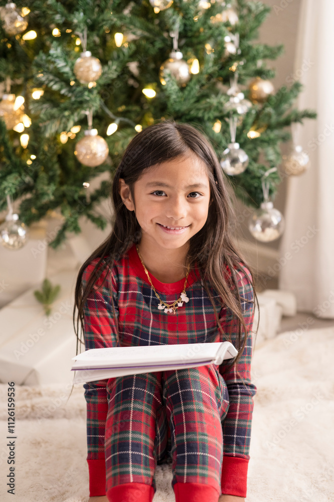 Girl smiling at camera in front of christmas tree Girl smiling at camera in front of christmas tree