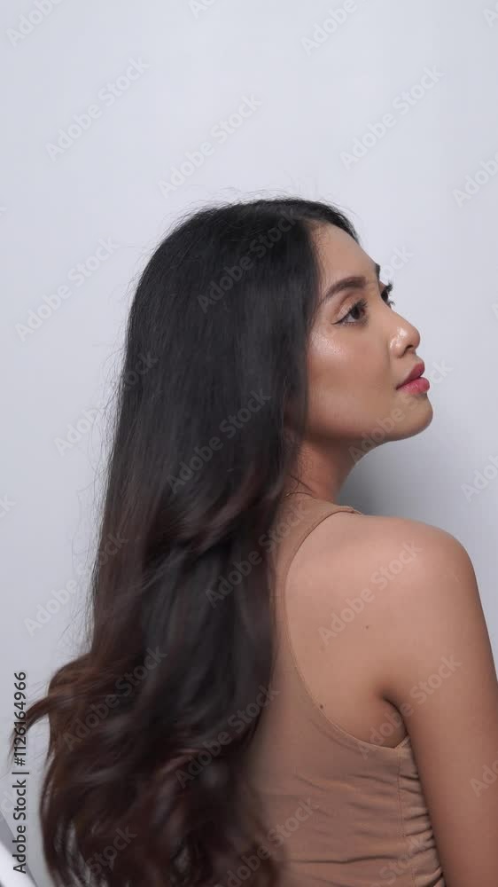 Beautiful young Asian woman with a long hairstyle lets down her hair. Beautiful young Asian woman with a long hairstyle lets down her hair.