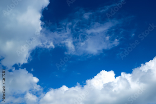 Blue sky with white clouds. The background is a clear blue sky without any clouds. A wide-angle view of the entire picture, showing vast and endless skies. photo