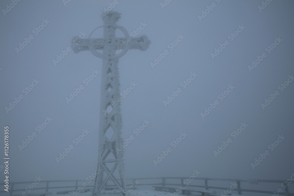 Winter landscape - Cross on the top of Tarnica mountain - the highest peak of Bieszczady mountain range in Poland