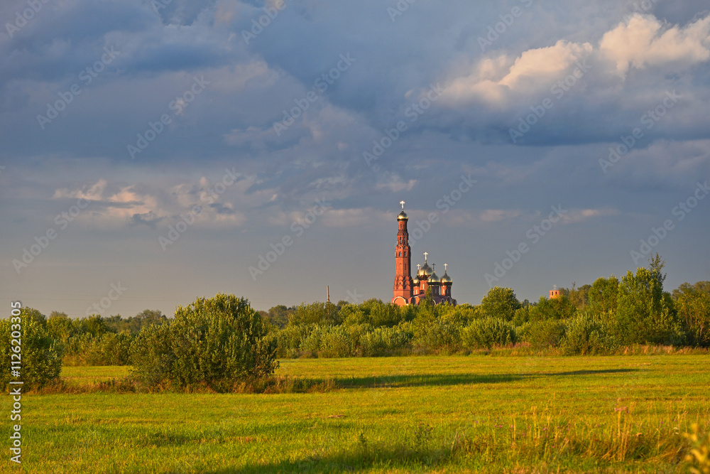 Big tower of the Resurrection Church in a sunset field