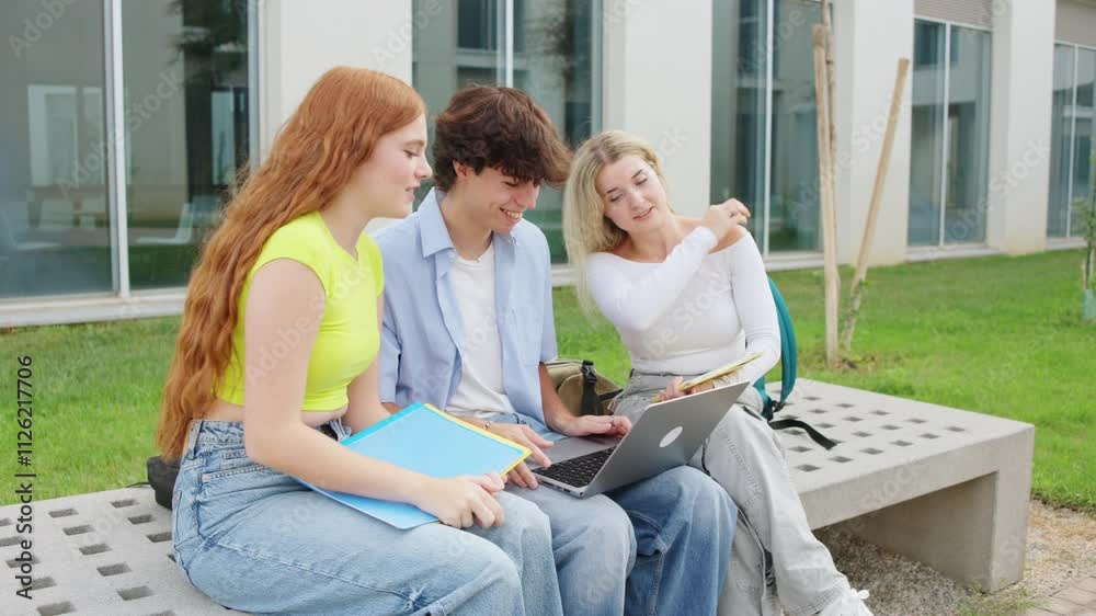 University students collaborating and celebrating success on campus bench University students collaborating and celebrating success on campus bench