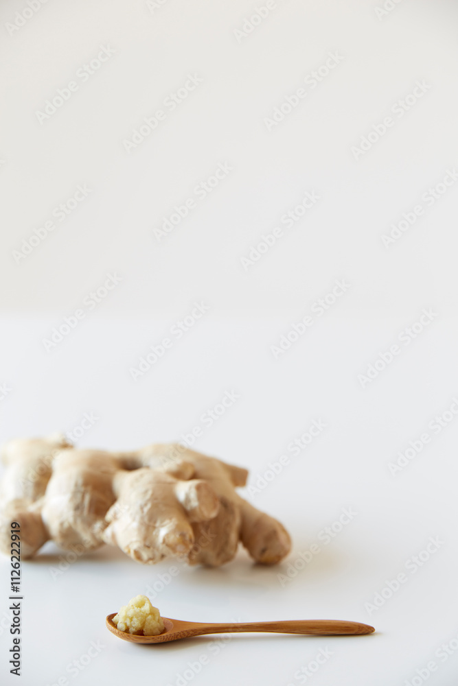 Spoon with large ginger and grated ginger on it Spoon with large ginger and grated ginger on it