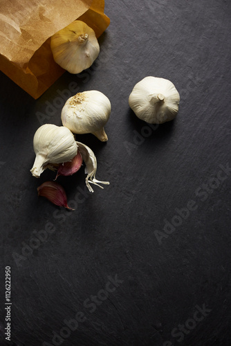 Purple garlic rolled out of a bag on a stone baking sheet