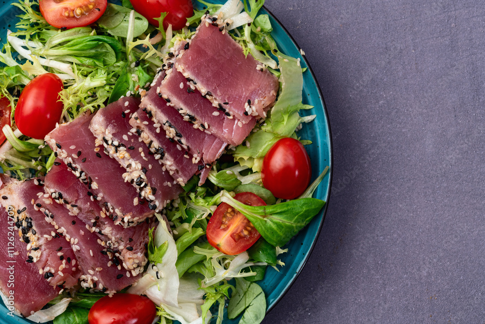Salad with raw tuna , sesame and cherry tomatoes photography . Top view Salad with raw tuna , sesame and cherry tomatoes photography . Top view