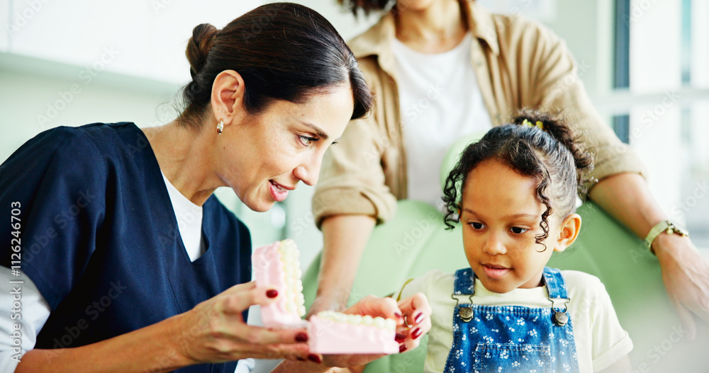 Dentist, girl and child with learning, model and info with listening, oral care and advice at clinic. Woman, mother and daughter with presentation, mold and teaching for dental wellness at hospital Dentist, girl and child with learning, model and info with listening, oral care and advice at clinic. Woman, mother and daughter with presentation, mold and teaching for dental wellness at hospital