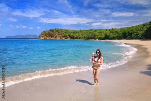 Young woman with a baby girl standing at Anse La Roche Beach, Carriacou Island, Grenada photo