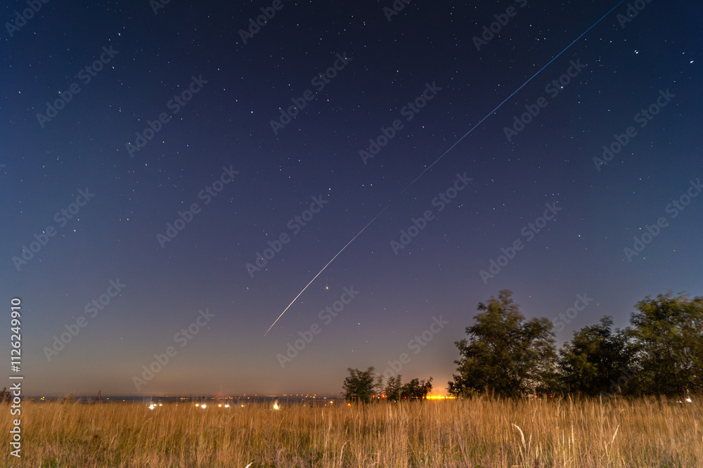 Fototapeta premium Meteor trail over starry field