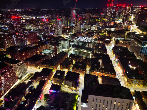 Aerial Night View of Illuminated Central Manchester City and Downtown Buildings, England United Kingdom. High Angle Footage Was Captured with Drone's Camera on May 4th, 2024 During Midnight. photo