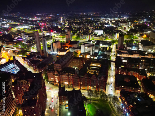 Aerial Night View of Illuminated Central Manchester City and Downtown Buildings, England United Kingdom. High Angle Footage Was Captured with Drone's Camera on May 4th, 2024 During Midnight. photo