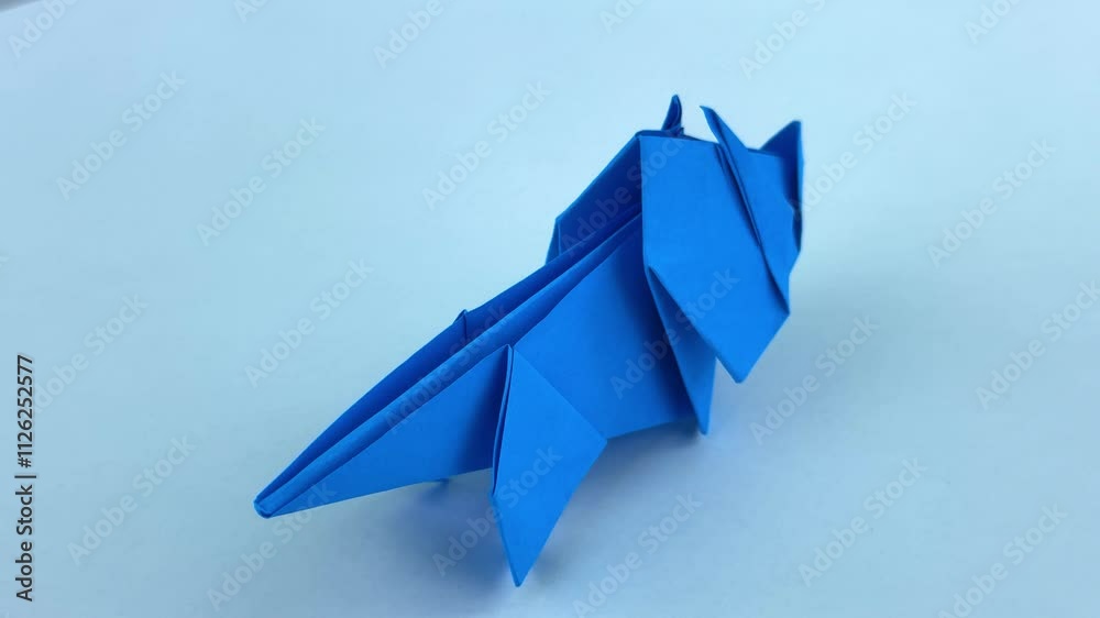 Blue Origami Rhinoceros Rotates on White Background