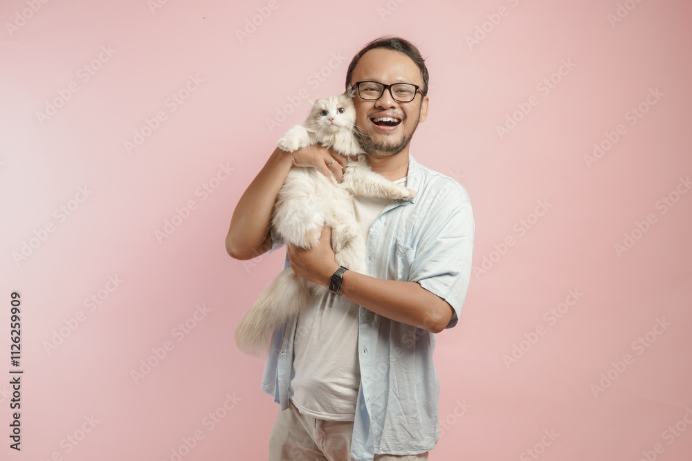 Lovely young Asian man holding a white ragdoll cat and smiling to the camera. Lovely young Asian man holding a white ragdoll cat and smiling to the camera.