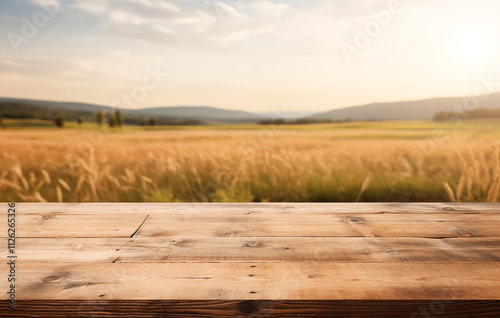 Rustic wooden table with a scenic green field background. A weathered wooden table in the foreground, with a vast field stretching out in the background
