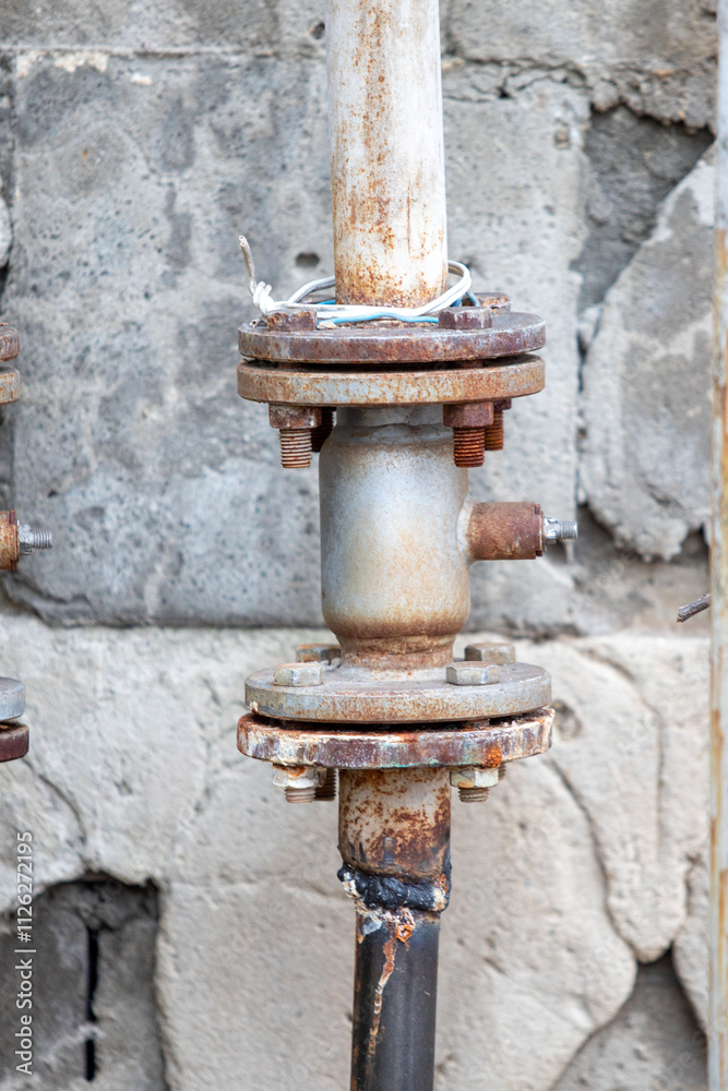A rusty pipe is leaning against a wall A rusty pipe is leaning against a wall