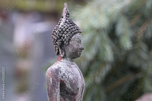 Photography Weathered Buddha statue with serene expression.
