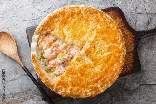 Cuadro en lienzo Homemade Salmon Pot Pie with carrots, corn, onion and peas and in a buttery pie crust closeup on the baking dish on the table