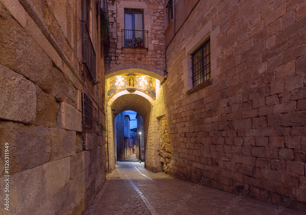 Obraz premium Old historic street illuminated at night in Girona, Spain